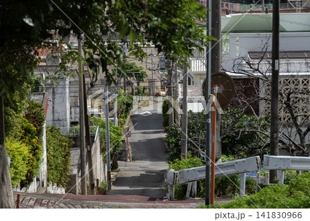 電柱や家々の影が道路にある天気の良い街の路地裏の坂道 電柱や家々の影が道路にある天気の良い街の路地裏の坂道 141830966