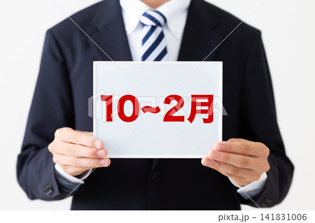 10〜2月のホワイトボードを持つリクルートスーツを着た若い男性ビジネスマン 10〜2月のホワイトボードを持つリクルートスーツを着た若い男性ビジネスマン 141831006