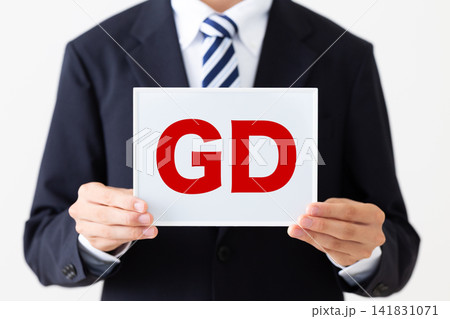 GDのホワイトボードを持つリクルートスーツを着た若い男性ビジネスマン GDのホワイトボードを持つリクルートスーツを着た若い男性ビジネスマン 141831071