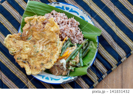 Traditional Indonesian Pecel with Red Rice and Omelet Traditional Indonesian Pecel with Red Rice and Omelet 141831432