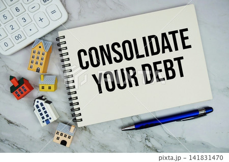 Consolidate Your Debt text written on notepad with house model and calculator on marble background 141831470