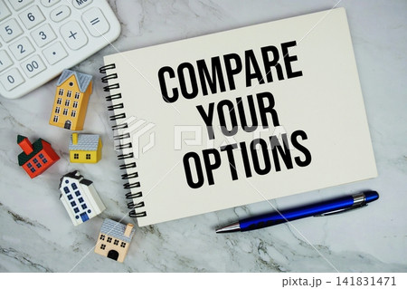 Compare Your Options text written on notepad with house model and calculator on marble background 141831471