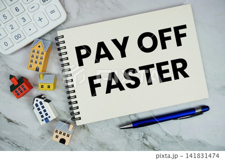 Pay Off Faster text written on notepad with house model and calculator on marble background 141831474