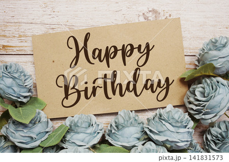 Happy Birthday text on paper card with rose flowers bouquet on wooden background Happy Birthday text on paper card with rose flowers bouquet on wooden background 141831573