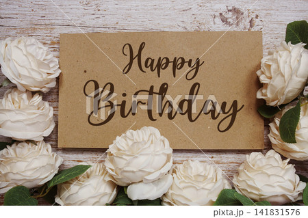 Happy Birthday text on paper card with rose flowers bouquet on wooden background Happy Birthday text on paper card with rose flowers bouquet on wooden background 141831576