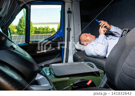 Van driver relaxing on the seats and using a smartphone during a break Van driver relaxing on the seats and using a smartphone during a break 141832642