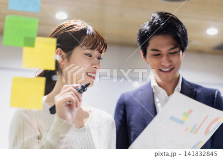 会議室で透明ボードを使って打合せするビジネスマン 141832845