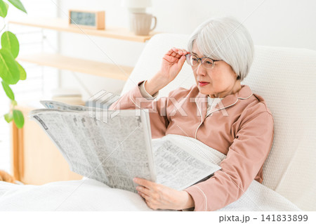 新聞を読むシニア,高齢者の女性(老眼,読めない) 新聞を読むシニア,高齢者の女性(老眼,読めない) 141833899