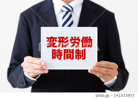 変形労働時間制のホワイトボードを持つリクルートスーツを着た若い男性ビジネスマン 変形労働時間制のホワイトボードを持つリクルートスーツを着た若い男性ビジネスマン 141833955