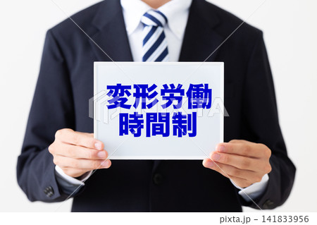 変形労働時間制のホワイトボードを持つリクルートスーツを着た若い男性ビジネスマン 変形労働時間制のホワイトボードを持つリクルートスーツを着た若い男性ビジネスマン 141833956