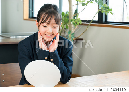 鏡を見る制服姿の小学生,中学生の女の子(スキンケア,ニキビ) 鏡を見る制服姿の小学生,中学生の女の子(スキンケア,ニキビ) 141834110