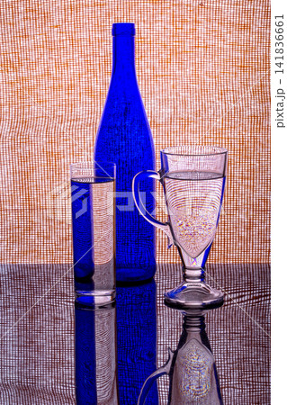 Still life with a blue bottle and a glass of water 141836661