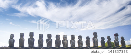 Ancient moai monoliths of Ahu Tongariki under blue sky in Easter Island, sunny landscape with copy space Ancient moai monoliths of Ahu Tongariki under blue sky in Easter Island, sunny landscape with copy space 141837558