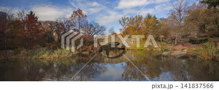 Stone arch bridge in autumn Central Park with reflection in pond, panoramic New York City view with copy space Stone arch bridge in autumn Central Park with reflection in pond, panoramic New York City view with copy space 141837566