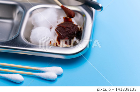 Sterile cotton ball and cotton swab with antiseptic iodine solution in stainless steel medical tray. Wound care preparation, first aid treatment, infection prevention, and clinical healthcare practice Sterile cotton ball and cotton swab with antiseptic iodine solution in stainless steel medical tray. Wound care preparation, first aid treatment, infection prevention, and clinical healthcare practice 141838135