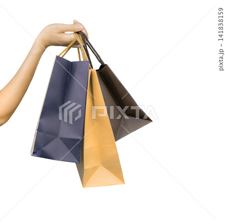 Woman carrying blue and brown paper shopping bags isolated on white background, representing consumer spending, retail purchasing, customer lifestyle, seasonal sales and Black Friday shopping concept. 141838159