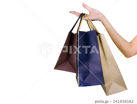 Woman carrying paper shopping bags isolated on white background. Adult woman hand hold three shopping bag with blue and brown color. Customer and shopping bag. Black Friday concept. 141838162