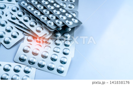 Silver blister packs for pharmaceutical tablets, healthcare packaging background. Global drug market, hospital medicine supply, pharmacy distribution and medical logistics. Pharmaceutical industry. Silver blister packs for pharmaceutical tablets, healthcare packaging background. Global drug market, hospital medicine supply, pharmacy distribution and medical logistics. Pharmaceutical industry. 141838176