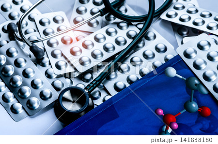 Medical stethoscope with pharmaceutical blister packs. Drug research, hospital healthcare, pharmacy innovation, clinical medicine and pharmaceutical science concepts. Pharmaceutical development. Medical stethoscope with pharmaceutical blister packs. Drug research, hospital healthcare, pharmacy innovation, clinical medicine and pharmaceutical science concepts. Pharmaceutical development. 141838180
