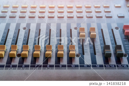 Audio sound mixer console. Sound mixing desk. Music mixer control panel in recording studio. Audio mixing console with faders and adjusting knob. Sound engineer. Sound mixer control radio broadcasting Audio sound mixer console. Sound mixing desk. Music mixer control panel in recording studio. Audio mixing console with faders and adjusting knob. Sound engineer. Sound mixer control radio broadcasting 141838218