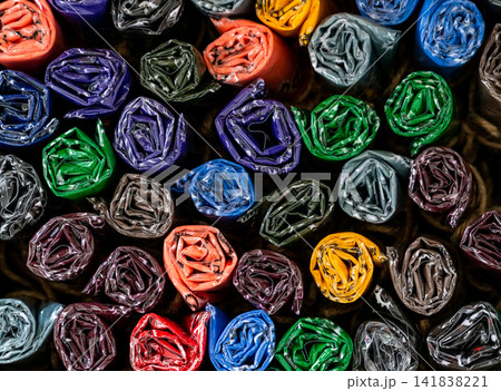 Colorful rolled handmade fabric scarves displayed in a souvenir shop, textile collection neatly arranged for gifts, fashion accessories, local handicrafts, tourism and retail merchandise concepts. 141838221