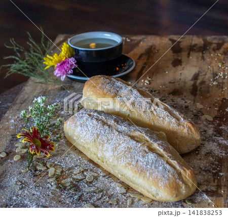 Homemade artisan bread loaves with seeds on wooden table. Rustic bakery food and cozy lifestyle concept. Homemade artisan bread loaves with seeds on wooden table. Rustic bakery food and cozy lifestyle concept. 141838253