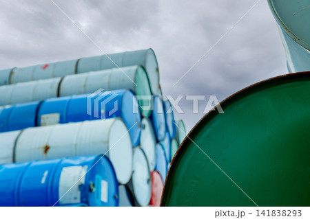 Selective focus on green old chemical barrels stack. Steel tank of flammable liquid. Hazard chemical barrel. Industrial waste. Empty chemical barrels at the factory warehouse. Hazard waste. 141838293