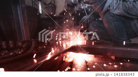 Welder welding metal with argon arc welding machine and has welding sparks. A man wears welding mask and protective gloves. Safety in industrial workplace. Welder working with safety. Steel industry. Welder welding metal with argon arc welding machine and has welding sparks. A man wears welding mask and protective gloves. Safety in industrial workplace. Welder working with safety. Steel industry. 141838343