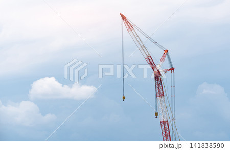 Crawler crane against blue sky and white clouds. Real estate industry. Red-white crane use reel lift up equipment in construction site. Crane for rent. Crane dealership for construction business. Crawler crane against blue sky and white clouds. Real estate industry. Red-white crane use reel lift up equipment in construction site. Crane for rent. Crane dealership for construction business. 141838590