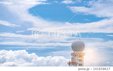 Weather observations radar dome station against blue sky and white fluffy clouds. Aeronautical meteorological observations station tower use for safety aircraft in aviation business. Spherical tower. Weather observations radar dome station against blue sky and white fluffy clouds. Aeronautical meteorological observations station tower use for safety aircraft in aviation business. Spherical tower. 141838617