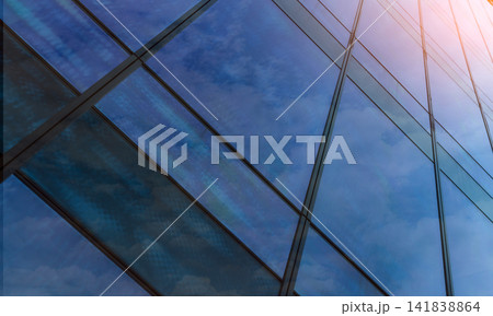 Perspective view of modern futuristic glass building abstract background. Exterior of office glass building architecture. Reflection in transparent glass of business building. Company glass window. Perspective view of modern futuristic glass building abstract background. Exterior of office glass building architecture. Reflection in transparent glass of business building. Company glass window. 141838864