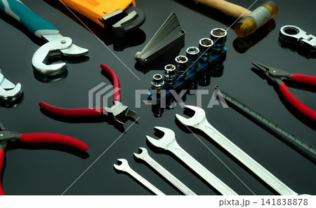 Set of mechanic tools on dark background. Chrome wrenches or spanners, hexagon socket, end cutter pliers, locking pliers, pincers, feeler gauge, bent wrench and hammer. Chrome vanadium spanner wrench. Set of mechanic tools on dark background. Chrome wrenches or spanners, hexagon socket, end cutter pliers, locking pliers, pincers, feeler gauge, bent wrench and hammer. Chrome vanadium spanner wrench. 141838878