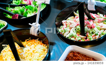Salad bar buffet at restaurant. Fresh salad bar buffet for lunch or dinner. Healthy food. Celery and crab stick sliced in black bowl on counter. Catering food. Banquet service. Vegetarian food. Salad bar buffet at restaurant. Fresh salad bar buffet for lunch or dinner. Healthy food. Celery and crab stick sliced in black bowl on counter. Catering food. Banquet service. Vegetarian food. 141839059