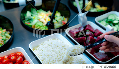 Hand holding spoon with boiled Job's tears at salad bar. Salad bar buffet at the restaurant. Fresh salad bar buffet for lunch or dinner. Healthy food. Catering food. Banquet service. Vegetarian food. 141839066