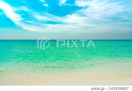 Crystal clear turquoise tropical sea with white sandy beach beneath blue sky. Peaceful summer seascape, travel destination, coastal nature. Tropical paradise, coastal scenery, summer vacation. Crystal clear turquoise tropical sea with white sandy beach beneath blue sky. Peaceful summer seascape, travel destination, coastal nature. Tropical paradise, coastal scenery, summer vacation. 141839087