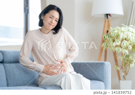 リビングで体調が悪いミドルの女性 リビングで体調が悪いミドルの女性 141839752