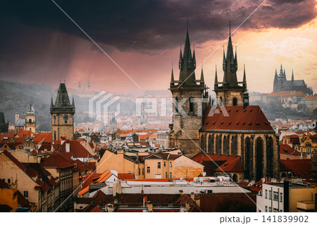 Dramatic storm sky over Prague rooftops and Tyn Church Dramatic storm sky over Prague rooftops and Tyn Church 141839902