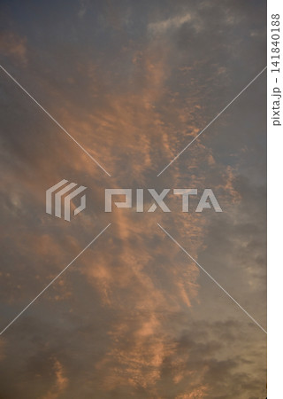 Dramatic orange sunset sky covered with delicate cirrus clouds, creating a warm atmospheric scene with vibrant colors and soft natural light. Dramatic orange sunset sky covered with delicate cirrus clouds, creating a warm atmospheric scene with vibrant colors and soft natural light. 141840188