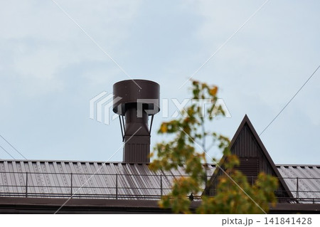 Industrial Ventilation Chimney Pipe on Metal Roof Exterior Industrial Ventilation Chimney Pipe on Metal Roof Exterior 141841428