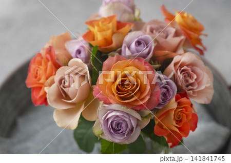 ガラス花瓶に活けられたオレンジやパープルの色鮮やかなバラの花束 ガラス花瓶に活けられたオレンジやパープルの色鮮やかなバラの花束 141841745