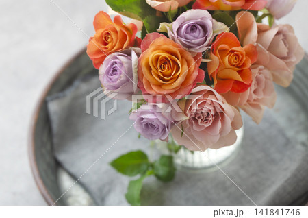 ガラス花瓶に活けられたオレンジやパープルの色鮮やかなバラの花束 ガラス花瓶に活けられたオレンジやパープルの色鮮やかなバラの花束 141841746