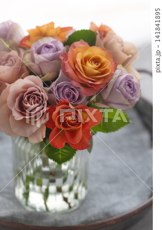 ガラス花瓶に活けられたオレンジやパープルの色鮮やかなバラの花束 ガラス花瓶に活けられたオレンジやパープルの色鮮やかなバラの花束 141841895