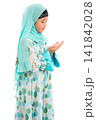 Side view portrait of cute young Asian Muslim girl praying with open hands isolated on white background. 141842028
