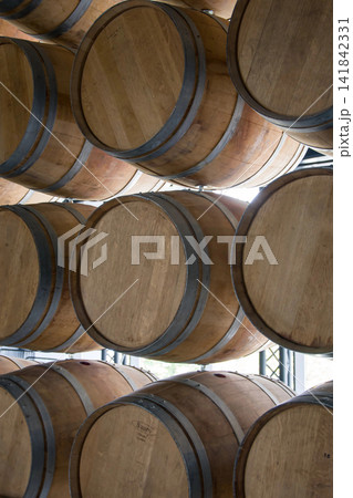 Wooden barrels stand on top of each other, wine storage, part of the interior, the structure of the tree. Wooden barrels stand on top of each other, wine storage, part of the interior, the structure of the tree. 141842331