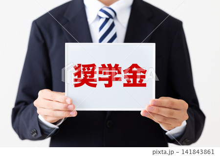 奨学金のホワイトボードを持つリクルートスーツを着た若い男性ビジネスマン 141843861