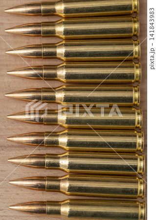 Closeup of brass rifle cartridges arranged in neat parallel rows Closeup of brass rifle cartridges arranged in neat parallel rows 141843983