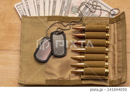 Military wallet with dollar bills dog tags and rifle cartridges Military wallet with dollar bills dog tags and rifle cartridges 141844050
