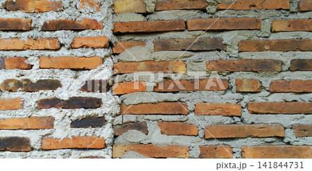 Exposed orange brick wall with thick cement mortar texture 141844731