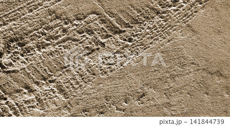Textured concrete wall with a cream and light brown stucco finish. 141844739
