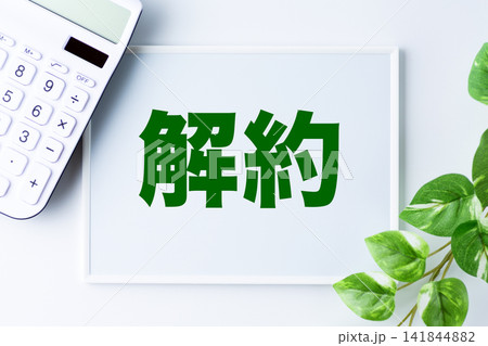 解約の文字のホワイトボードと白い電卓 解約の文字のホワイトボードと白い電卓 141844882